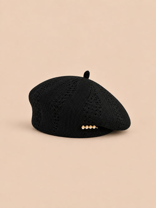 Béret ajouré style japonais noir, vue de trois quarts sur fond pêche sable
